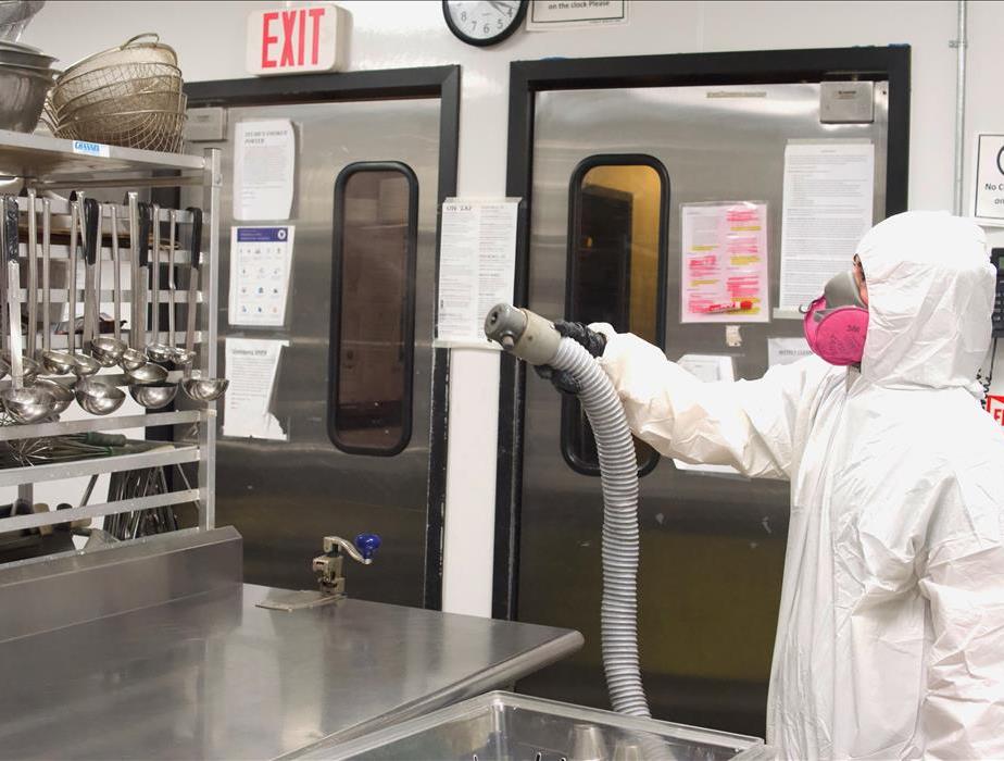 technician disinfecting a commercial kitchen